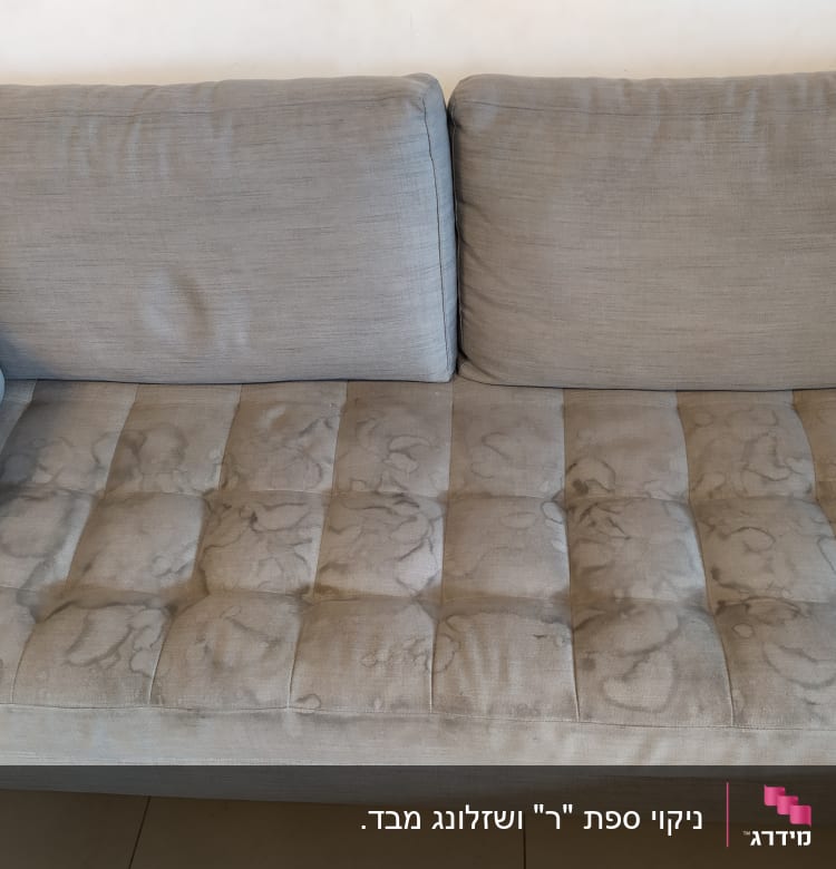 ספה אפורה עם כתמים על המושב